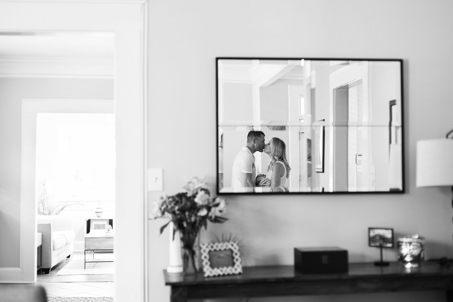 new parents reflected in mirror with newborn