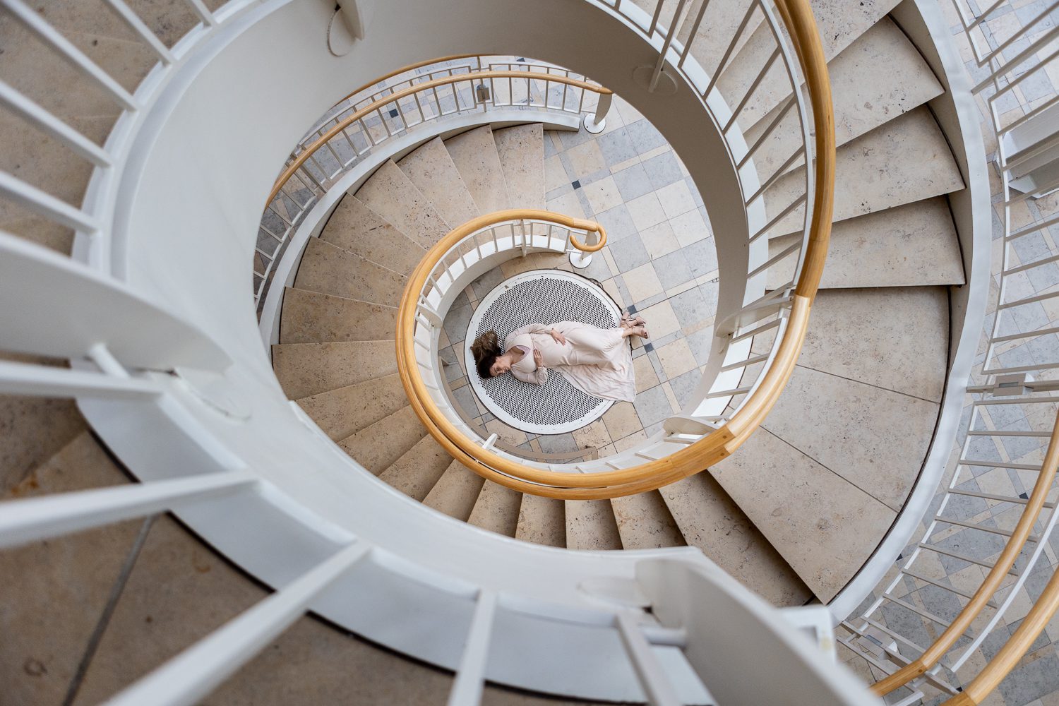pregnant mom laying on floor through spiral staircase at Fern Bank