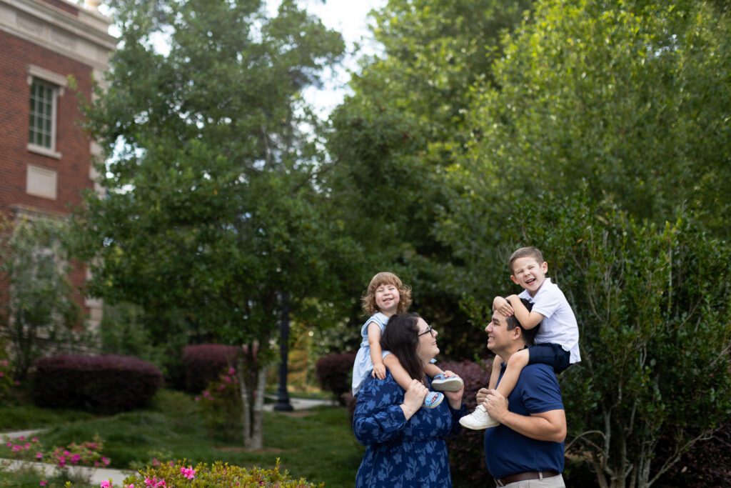 kids sitting on mom and dad's shoulder in downtown Alpharetta